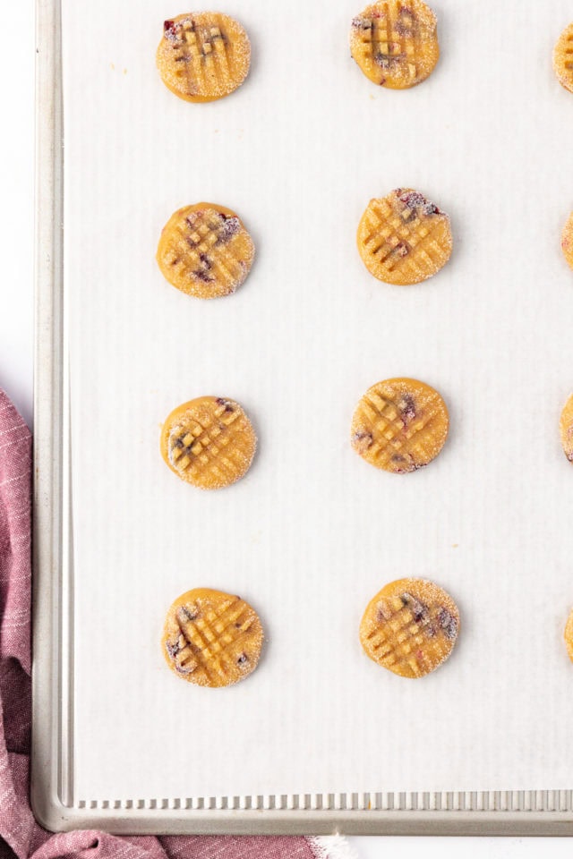 overhead view of macadamia butter cookies on a parchment-lined baking sheet ready to go into the oven