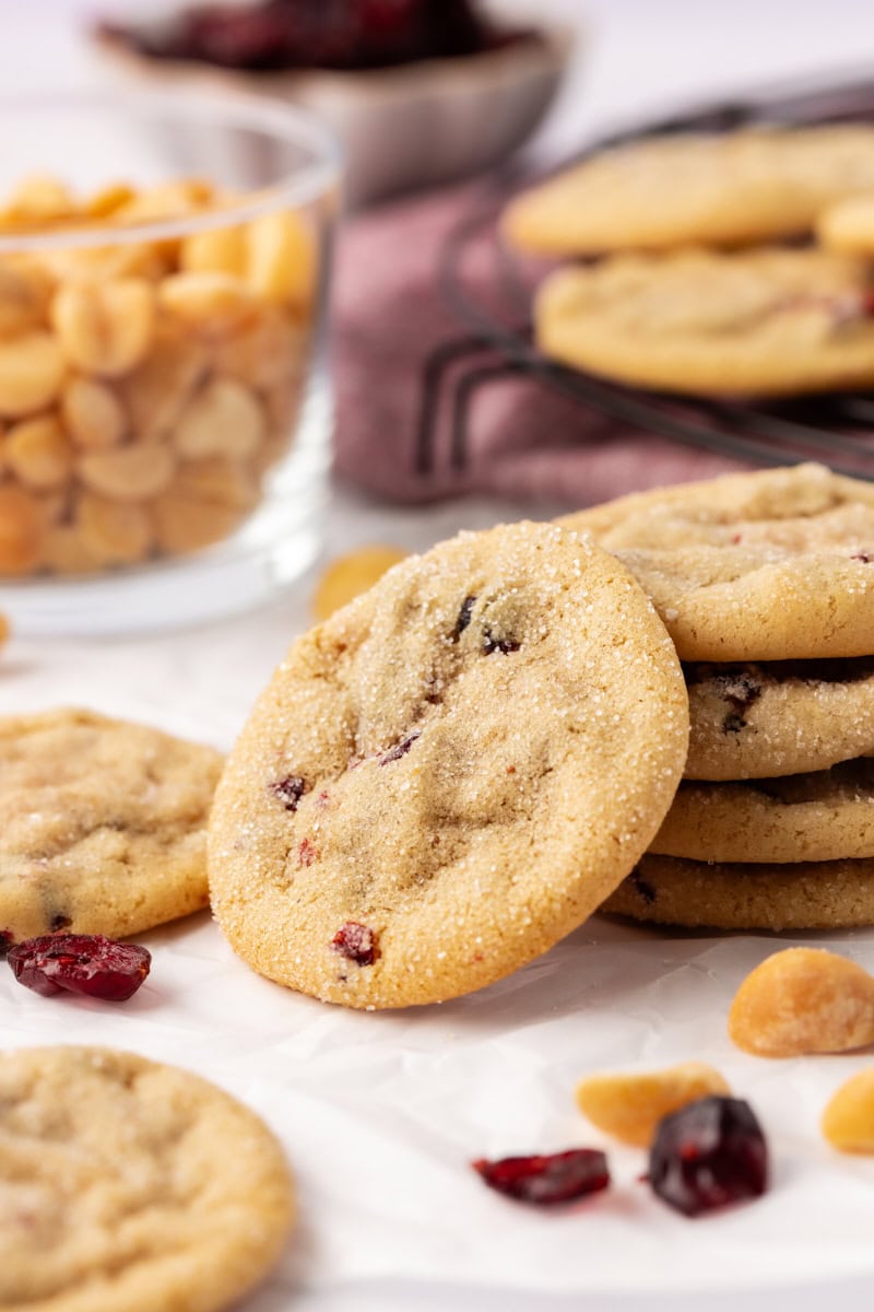 a macadamia butter cookie propped against a stack of four more cookies