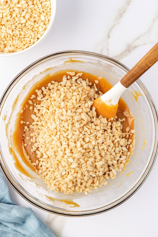 overhead view of rice cereal added to peanut butter mixture for chocolate peanut butter cereal bars