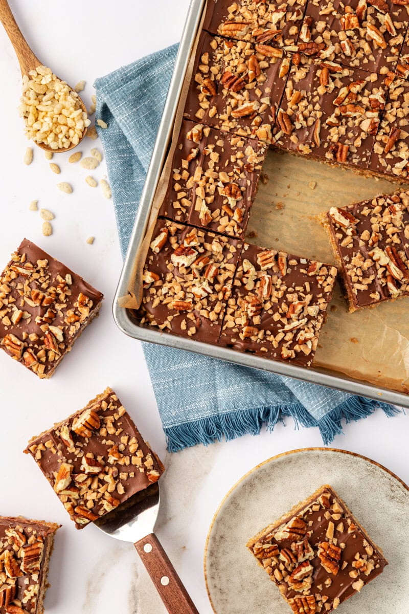 overhead view of chocolate peanut butter cereal bars in the pan, on a countertop, and on a plate