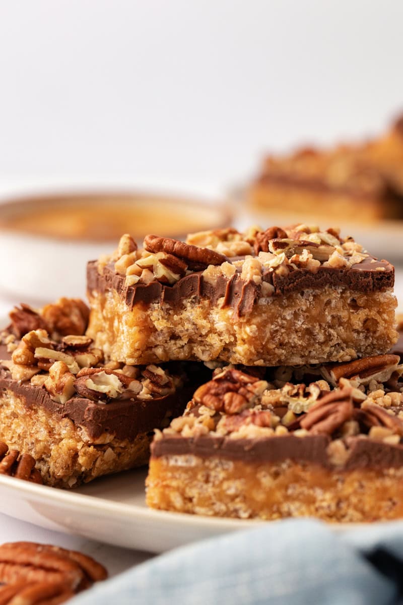 three stacked chocolate peanut butter cereal bars with a bite missing from the top bar