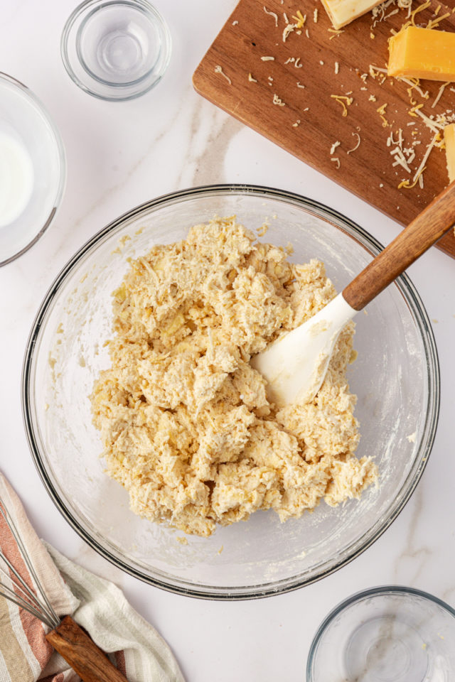 overhead view of three cheese biscuit dough in a glass mixing bowl