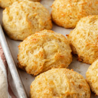 three cheese biscuits on a baking sheet