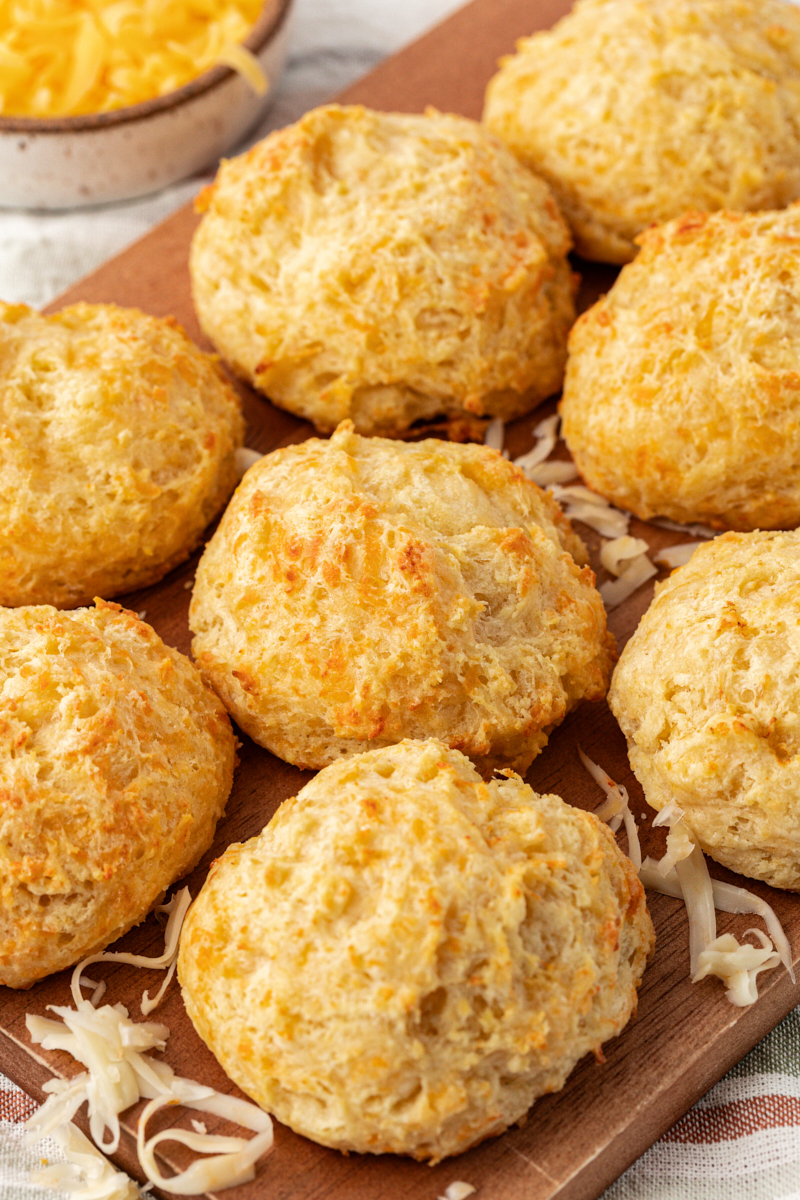 three cheese biscuits on a wooden serving board