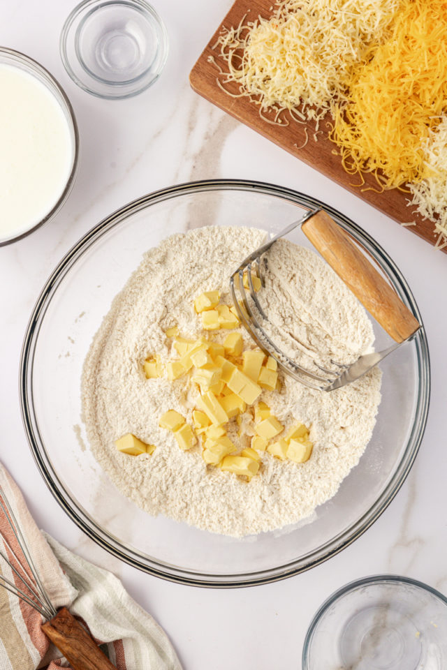 overhead view of cold cubed butter added to dry biscuit ingredients