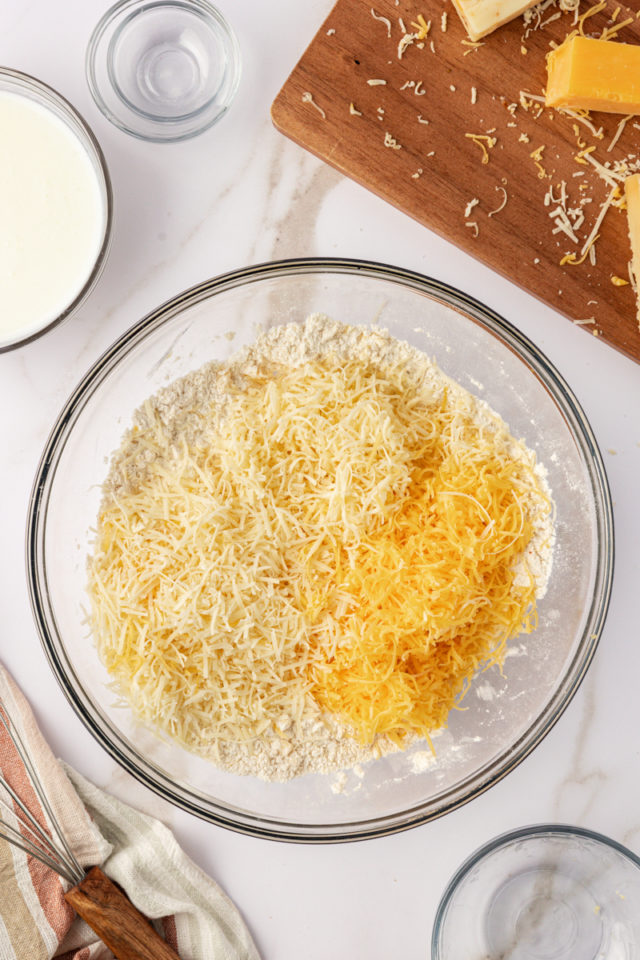 overhead view of cheeses added to biscuit dough