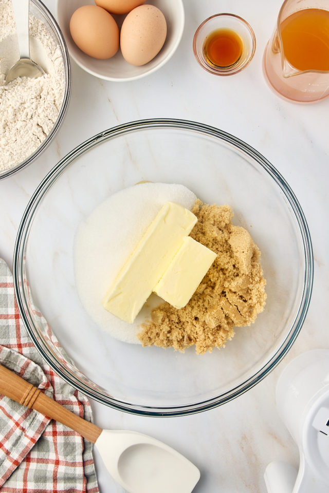 overhead view of butter, sugar, and brown sugar in a glass mixing bowl