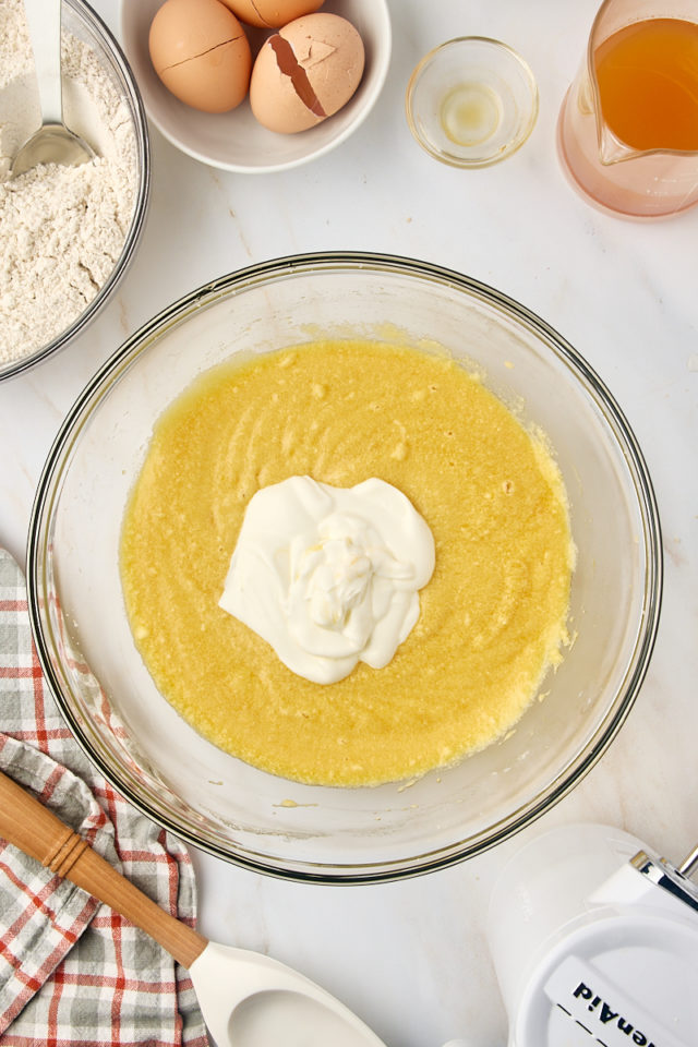 overhead view of sour cream added to apple cider donut cake batter