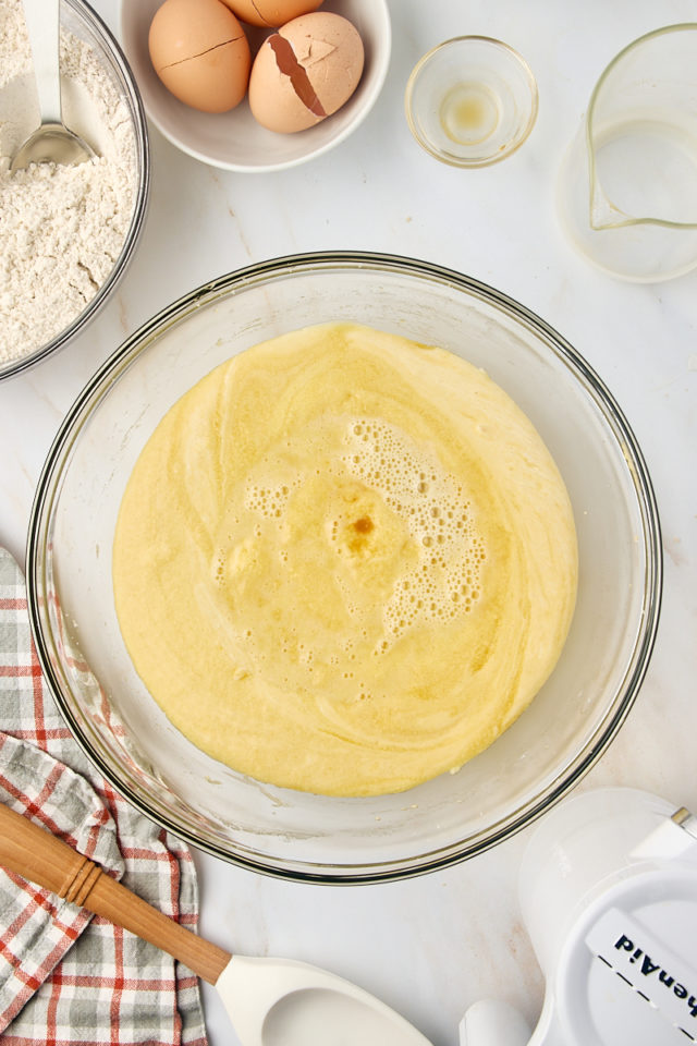 overhead view of apple cider added to cake batter