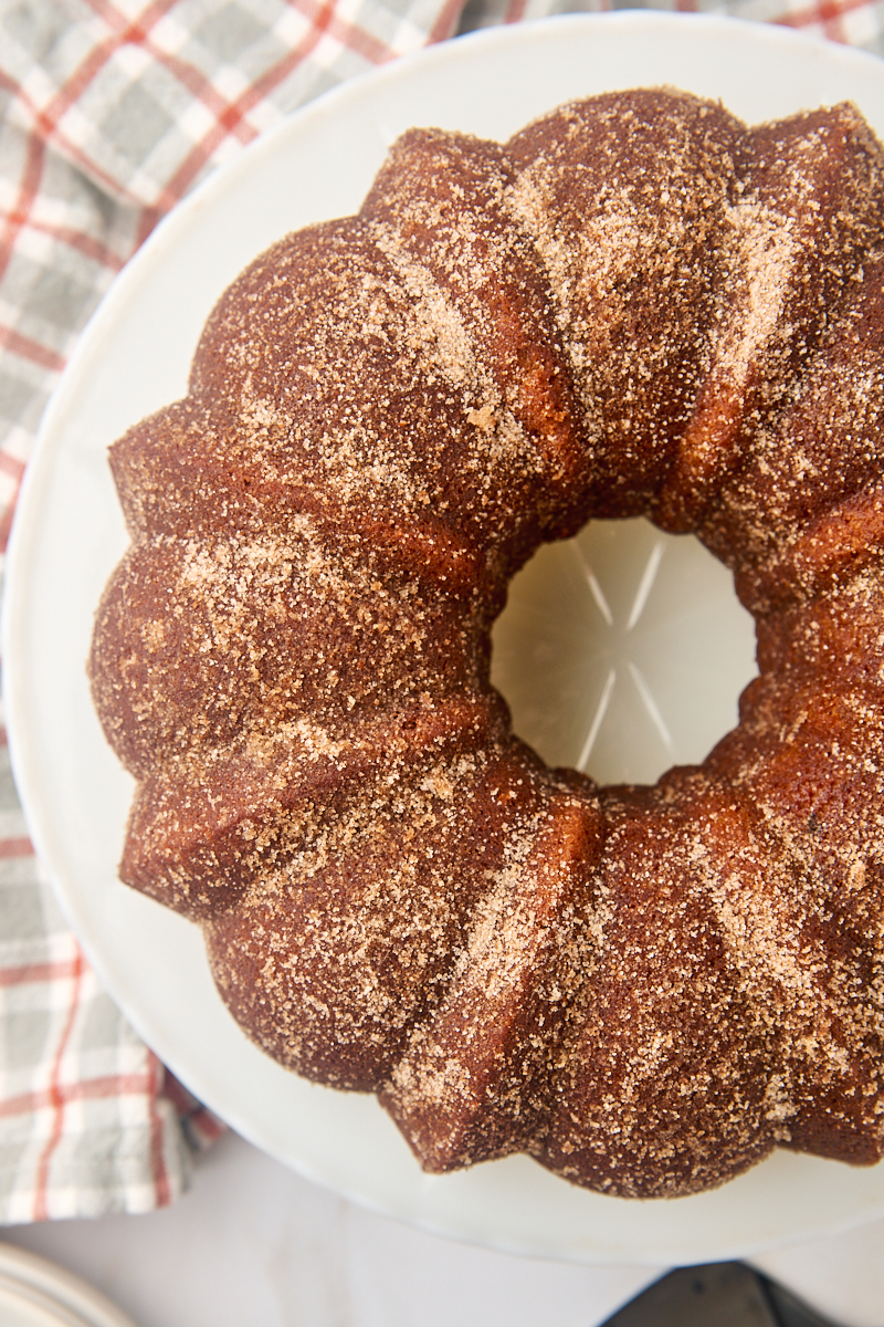 overhead view of apple cider donut cake on a white cake plate