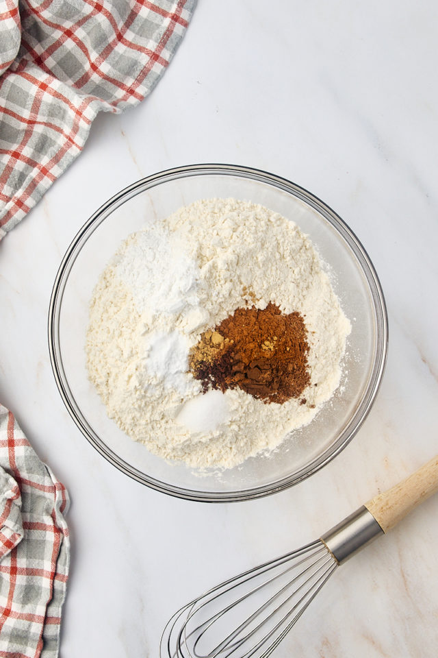 overhead view of flour, baking powder, salt, and spices in a mixing bowl