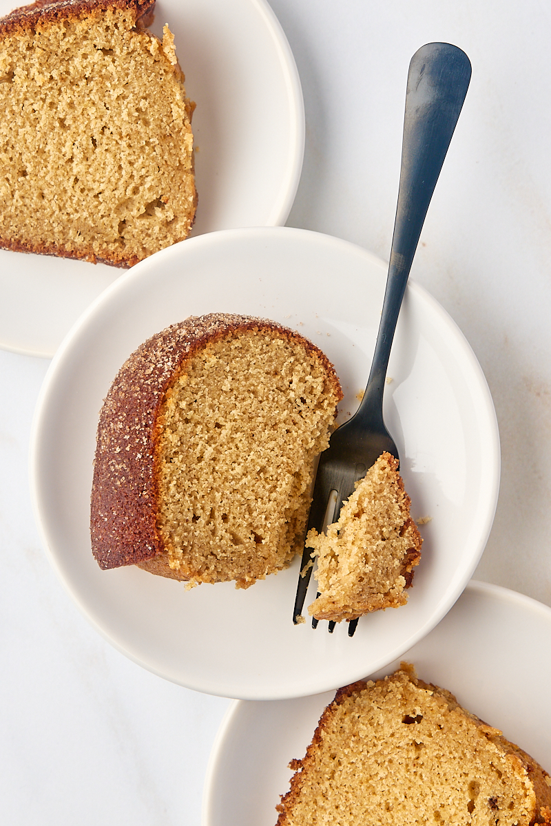 overhead view of three slices of apple cider donut cake on white plates