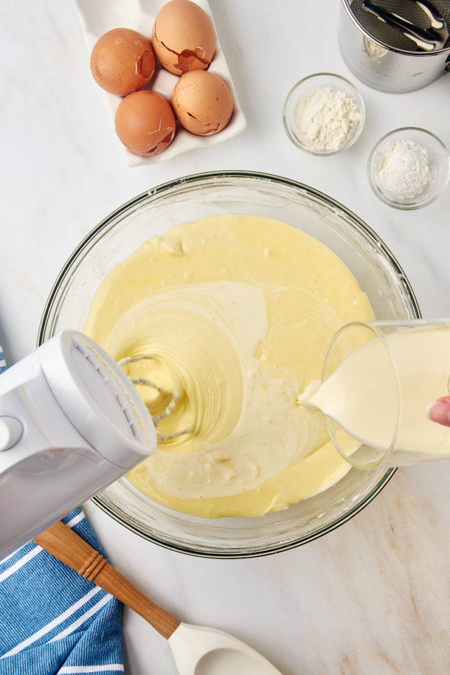 overhead view of cream being added to basque cheesecake batter