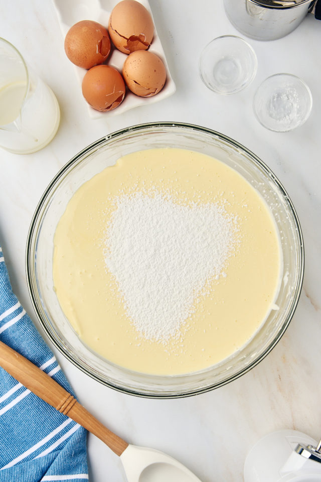 overhead view of flour and cornstarch added to basque cheesecake batter