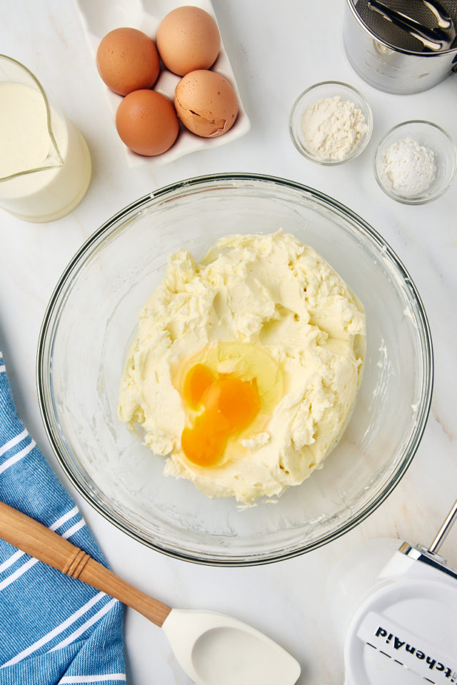 overhead view of egg added to cheesecake mixture