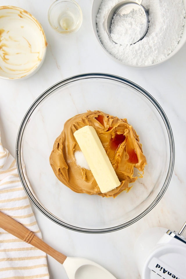 overhead view of peanut butter, butter, vanilla, and salt in a glass mixing bowl