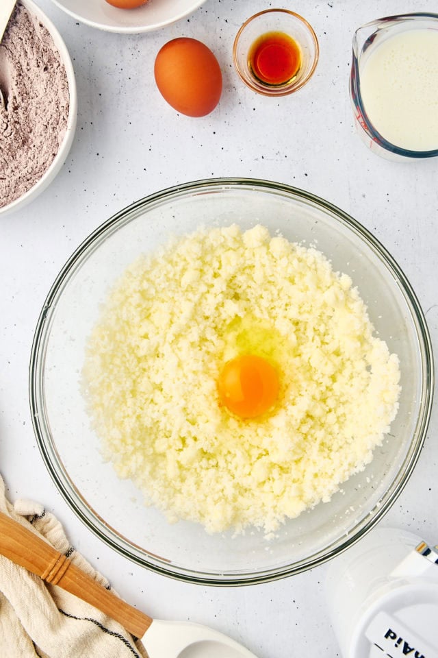 overhead view of egg added to creamed butter and sugar