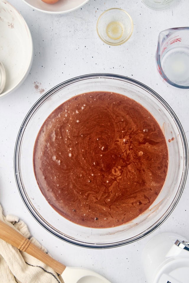 overhead view of mahogany cake batter in a glass mixing bowl