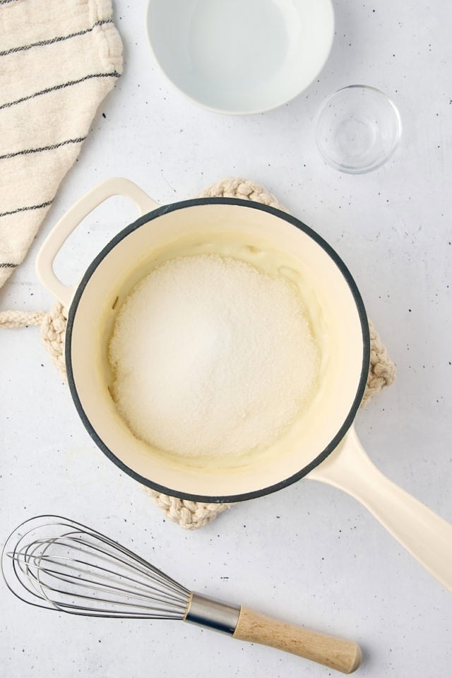 overhead view of sugar added to milk mixture for ermine frosting