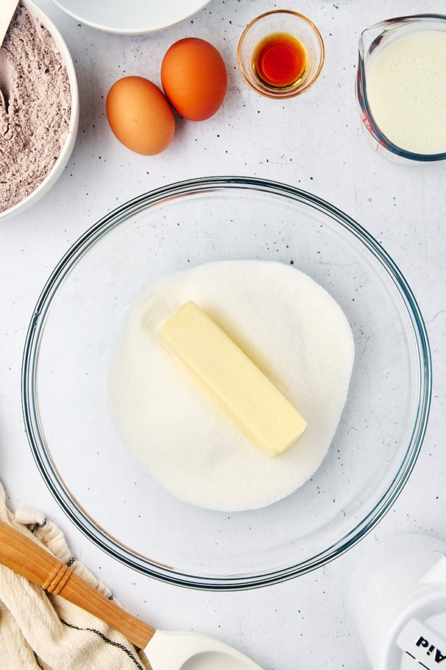 overhead view of butter and sugar in a glass mixing bowl