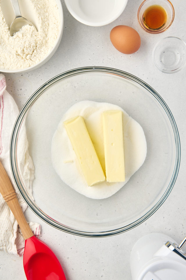 overhead view of butter and sugar in a glass mixing bowl