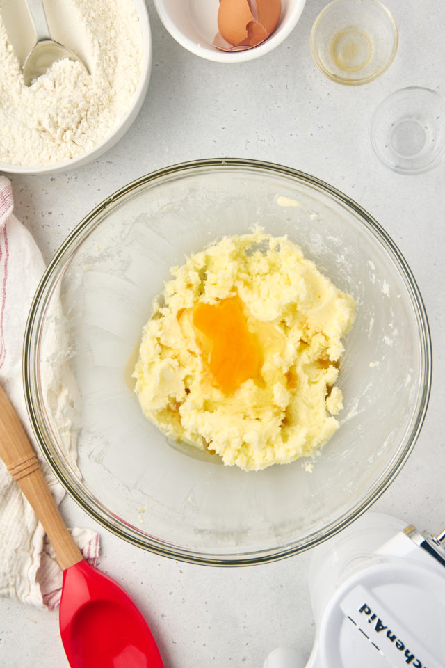 overhead view of egg added to creamed butter and sugar