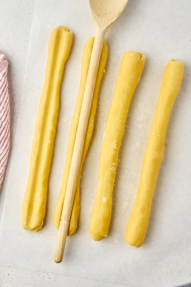 overhead view of grooves being made in raspberry ribbon cookie dough logs