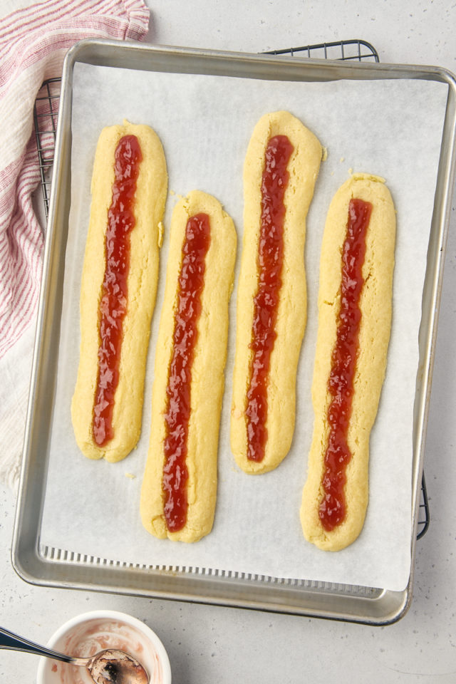 overhead view of jam-filled raspberry ribbon cookies ready to go back into the oven