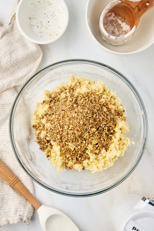 overhead view of ground nuts added to snowball cookie dough