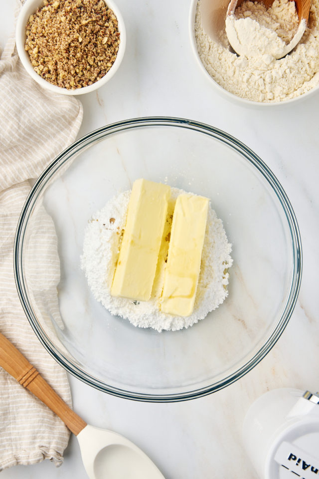 overhead view of butter and confectioners' sugar in a glass mixing bowl