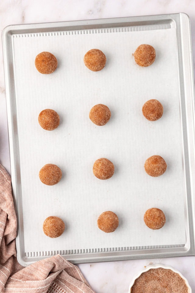 brown butter snickerdoodle cookie dough balls on a baking sheet ready to go into the oven