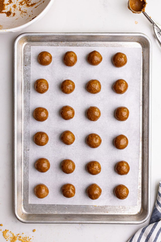 overhead view of gingerbread truffles rolled and placed on a baking sheet, ready to be dipped in chocolate