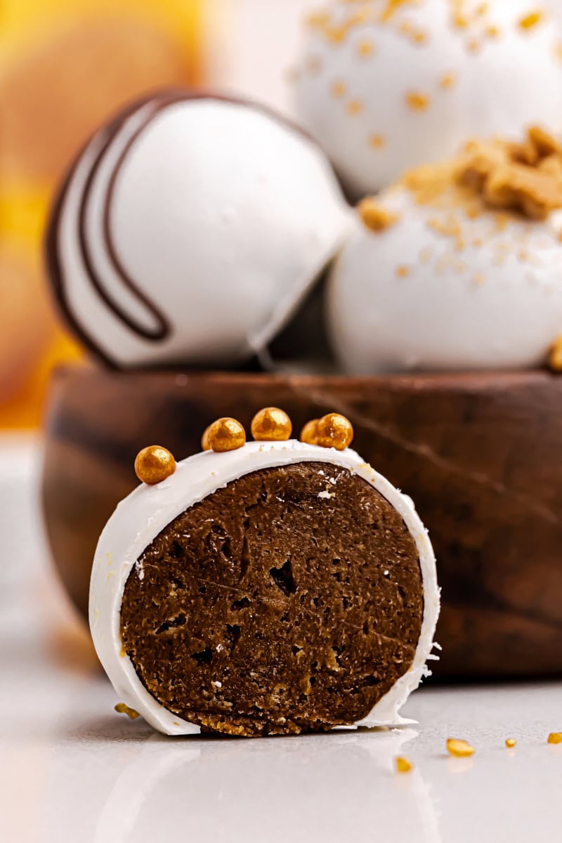 half of a gingerbread truffle beside a bowl of more truffles