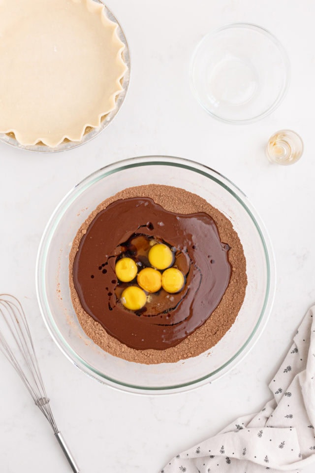 overhead view of eggs added to chocolate mixture for hot fudge pie