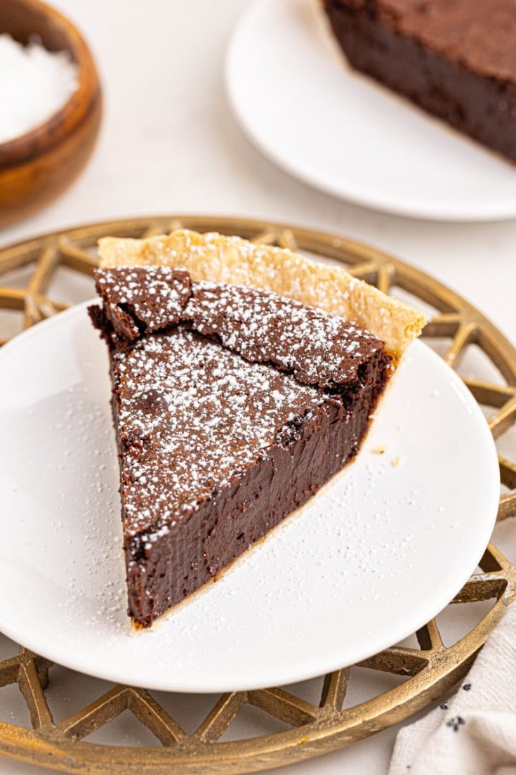 a slice of hot fudge pie with a sprinkling of confectioners' sugar on top