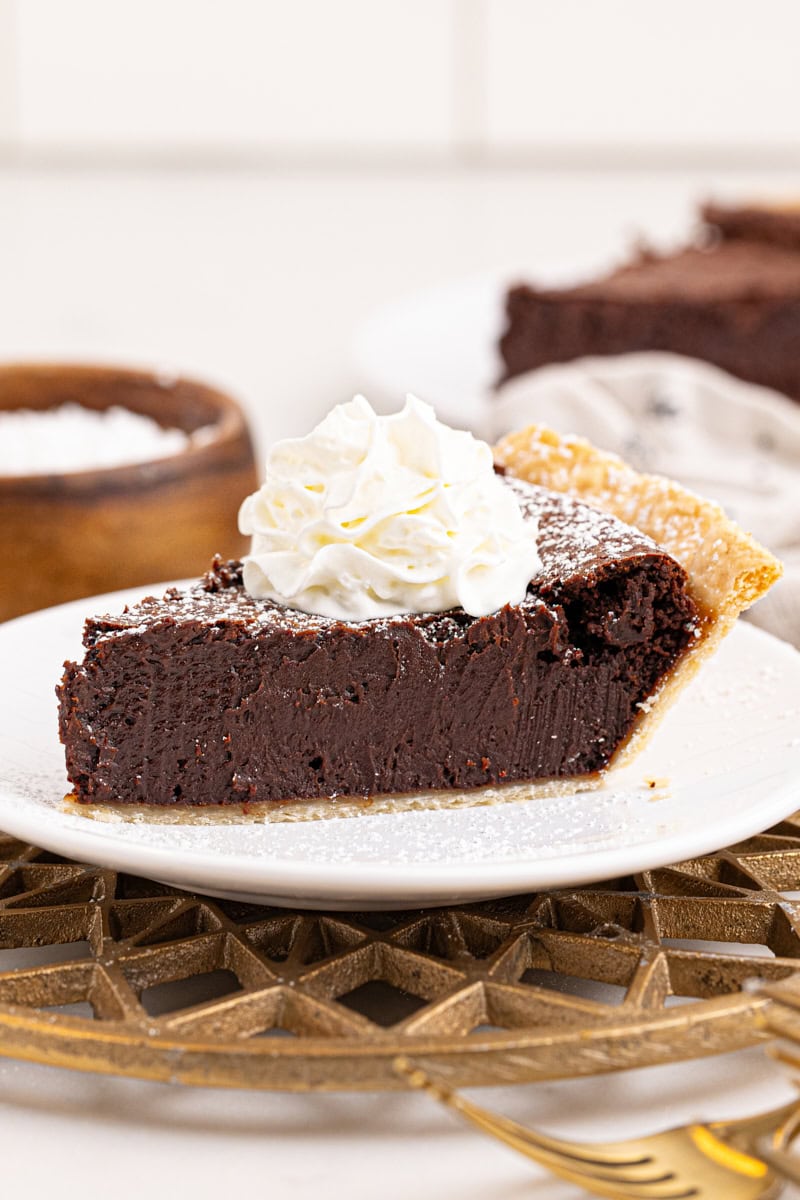 a slice of hot fudge pie topped with whipped cream