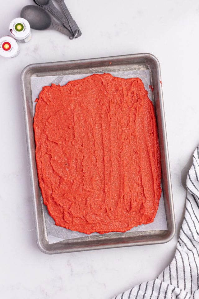 overhead view of red cookie dough spread in a baking pan