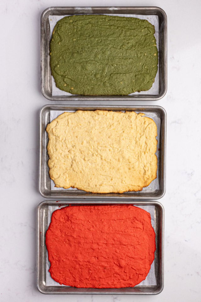 overhead view of three baked portions of Italian rainbow cookie dough in different colors