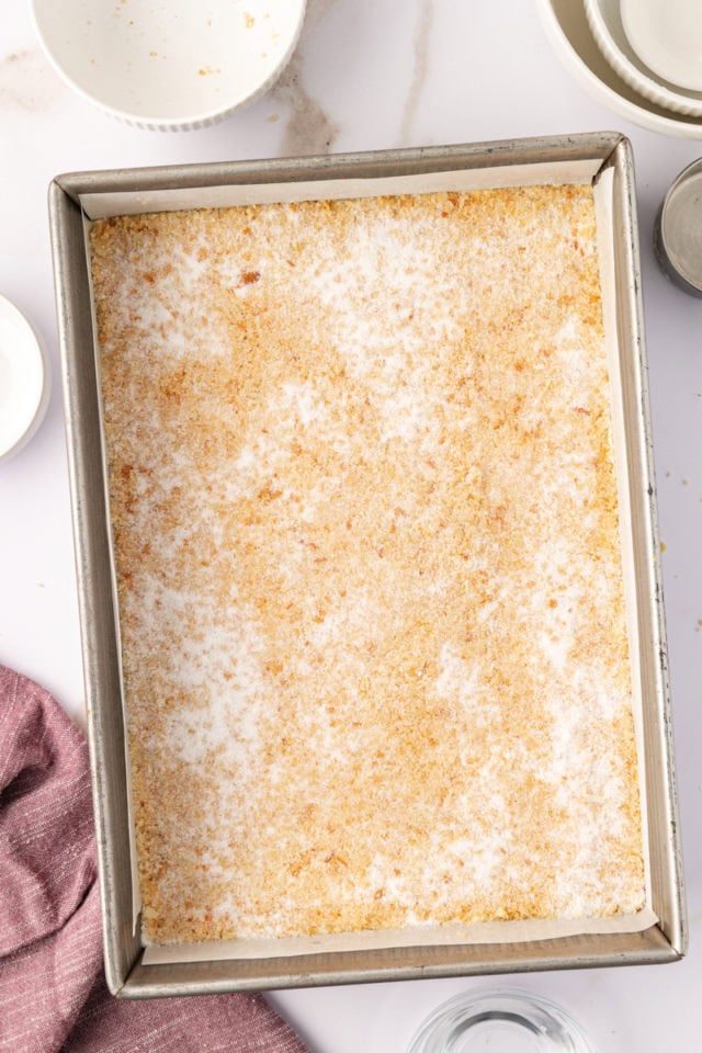 macadamia shortbread dough in a baking pan ready to go into the oven