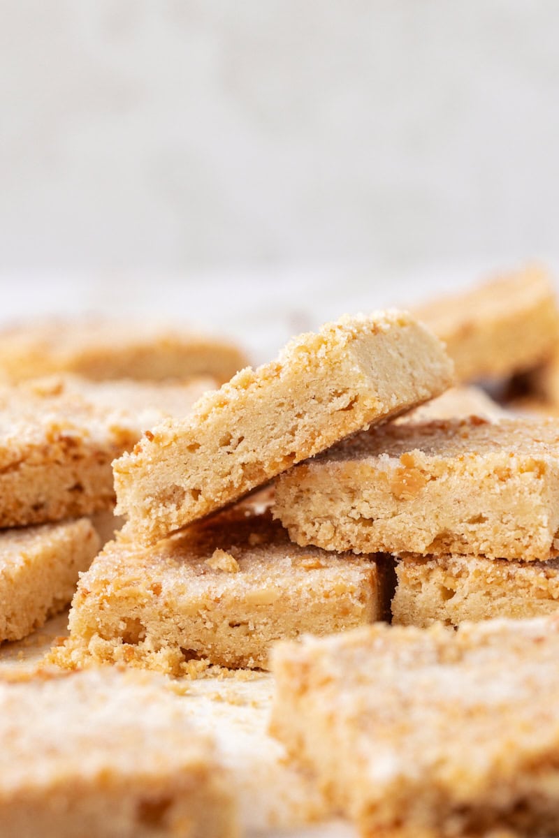 several macadamia shortbread stacked and piled on a marble countertop