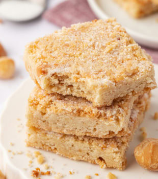 stack of three macadamia shortbread with a bite missing from the top cookie