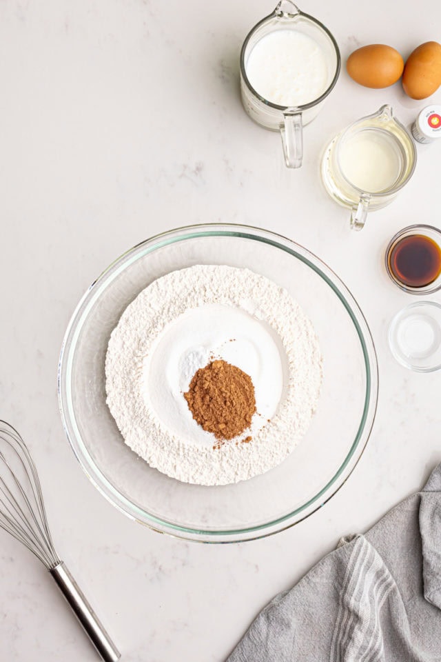 overhead view of flour, sugar, baking soda, salt, and cocoa powder in a mixing bowl