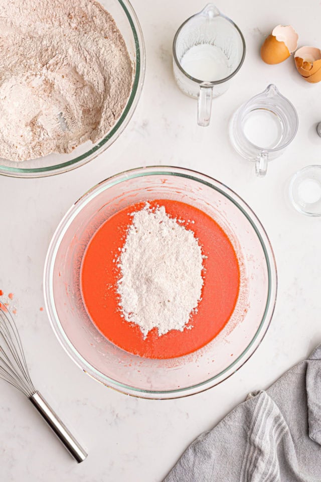 overhead view of dry ingredients added to wet ingredients for red velvet cake