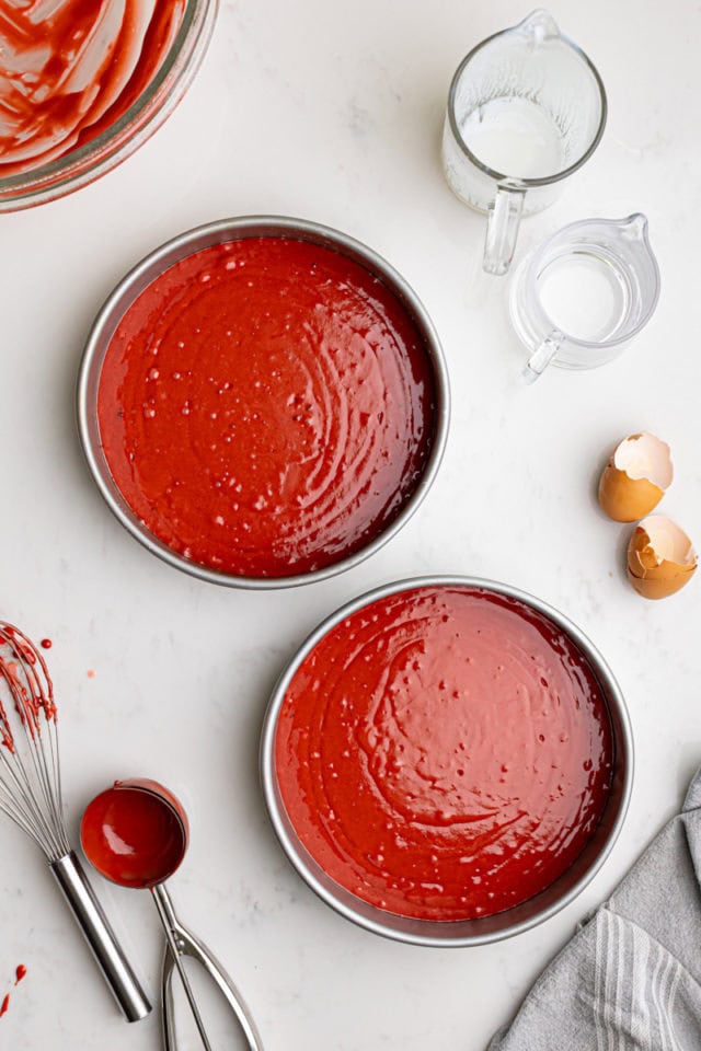 overhead view of red velvet cake batter divided between two cake pans