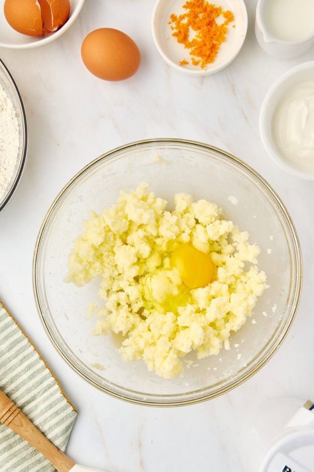 overhead view of egg added to creamed butter and sugar