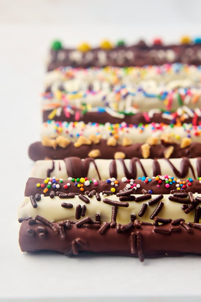 chocolate covered pretzel rods on a white surface