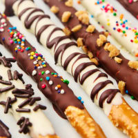 chocolate covered pretzel rods on a white surface