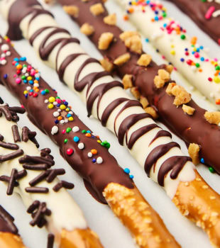 chocolate covered pretzel rods on a white surface