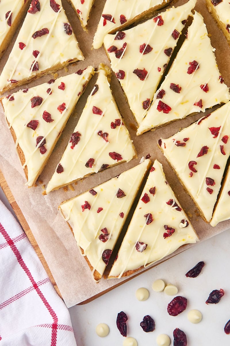 overhead view of several cranberry bliss bars on a cutting board