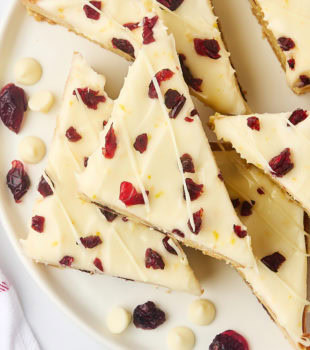 overhead view of several cranberry bliss bars on a white plate